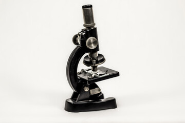 a small black and metallic microscope / isolated background
