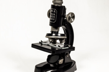 a small black and metallic microscope / isolated background