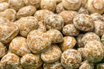 A lot of glazed gingerbread cookies, a bunch lies on a shop window.