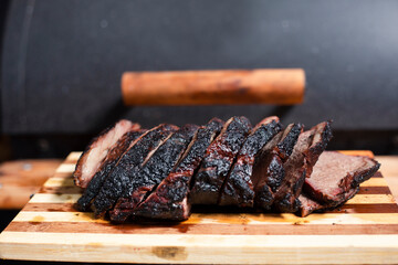 Grilled beef steak cut on a wooden board -meat flamed with torch - homemade barbecue - cooking meat on the grill