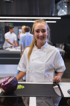 Portrait of female chef smiling at restaurant kitchen