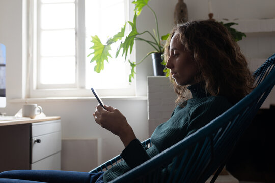 Woman using smartphone while sitting on a chair