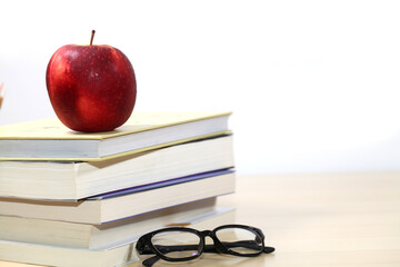 Composite image of school supplies on desk,  Apple, books and glasses on the desktop.