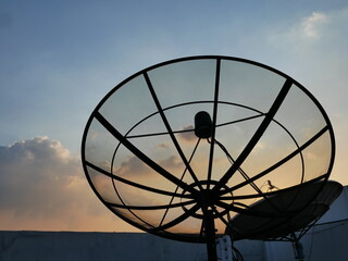 silhouette of satellite dish antennas at TV station.