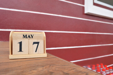 May 17, Number cube with wooden table beside the wall.