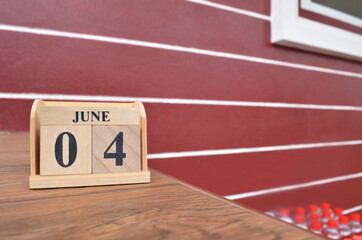 June 4, Number cube with wooden table beside the wall.