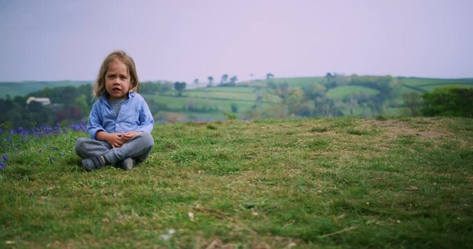 Little boy sitting in a meadow