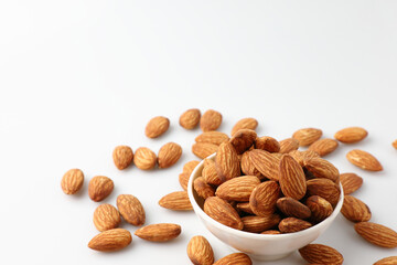 Almonds nuts in white bowl isolated on a white background with copy space is useful to help neutralize free radicals, help prevent Alzheimer's disease, helping repair the wear and tear on the body.