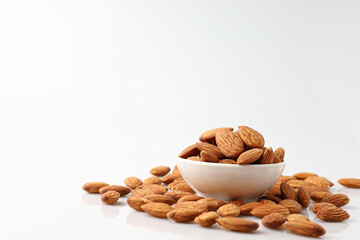 Almonds nuts in white bowl isolated on a white background with copy space is useful to help neutralize free radicals, help prevent Alzheimer's disease, helping repair the wear and tear on the body.