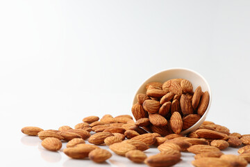Almonds nuts in white bowl isolated on a white background with copy space is useful to help neutralize free radicals, help prevent Alzheimer's disease, helping repair the wear and tear on the body.
