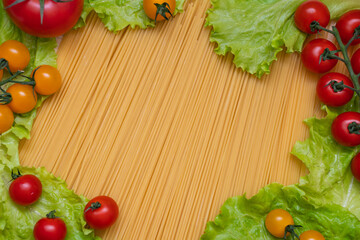 Obraz na płótnie Canvas Background from spaghetti. Frame for the recipe of products. View from above. Ingredients for Italian pasta tomatoes, cherry greens.