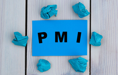 PMI - word on blue paper on a light background with crumpled pieces of paper