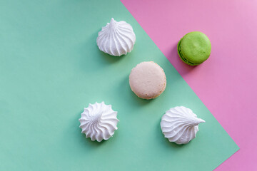 Flat lay of french macarons and meringues on colorful background. Top view.white meringues,Many sweet zephyrs. Trendy dessert image. Bakery products. Colorful cookies background.Copy space