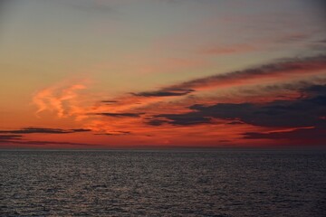 A cold orange sun sets on the North Sea. Fall. Cold evening. Photo from the side of the ship.