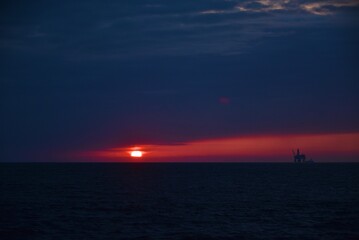 Autumn red sunset over the cold polar sea. Red clouds, illuminated by the cold sun, over the horizon. Photo from the side of the ship.