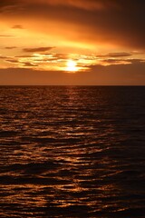 Autumn red sunset over the cold polar sea. Red clouds, illuminated by the cold sun, over the horizon. Photo from the side of the ship.