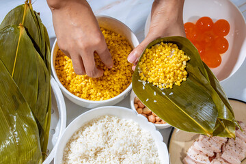 Families make zongzi with spiced fresh meat on Dragon Boat Festival