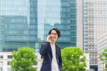 男性　スマートフォン　ジャケット　オフィス街