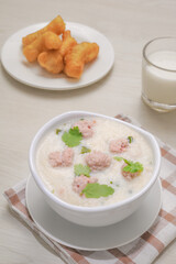 Thai Breakfast, Boiled rice with pork in white bowl on wooden table.
