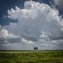 A welcome to Kansas highway sign with impending severe weather in the summertime