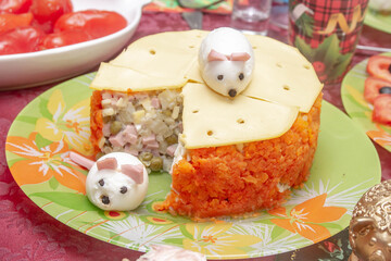 Olivier salad on the new year's table. Decorations for Christmas in the form of a mouse from an egg. New year according to the Chinese calendar, Oriental style.