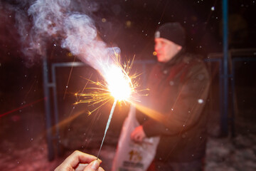 It's dangerous to light fireworks at home. Keep the child away from the fire. Light bright sparklers on new year's holiday, Christmas, birthday holiday.