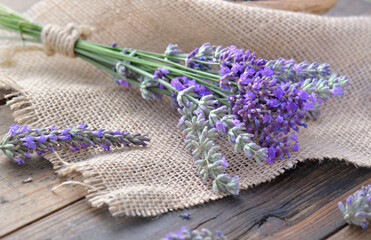 bouquet of lavender flowers on piece of fabric on  wooden background