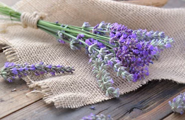 Fotobehang bouquet of lavender flowers on piece of fabric on  wooden background © coco
