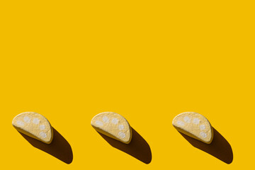 Several tasty marshmallows with hard shadows on a yellow background with copy space