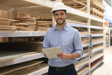 portrait of a smiling young warehouse worker working in a cash and carry wholesale store.