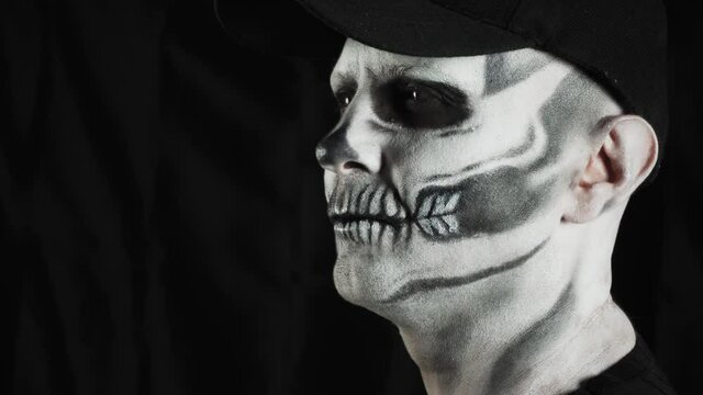 Makeup skeleton for Halloween. Human skeleton on a dark background. Man looks away