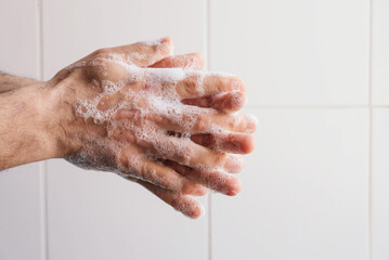 Fototapeta premium Man cleaning his hands using liquid disinfectant soap and water.