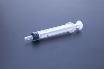 A syringe used for vaccinations against a gray background