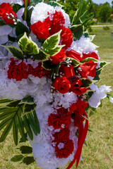 Red and White flowers arranged in the shape of cross. 