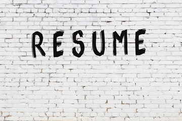 White wall with black paint inscription resume on it