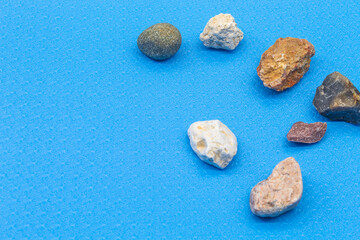 Fototapeta na wymiar Natural natural stones are placed on a blue background