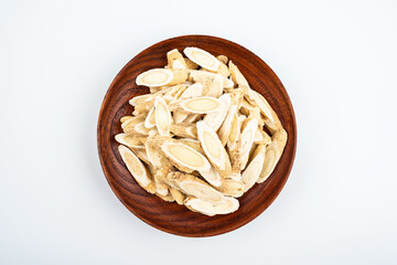 Astragalus membranaceus tablets on a plate on white background