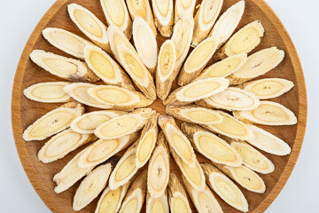 Astragalus membranaceus tablets on a plate on white background