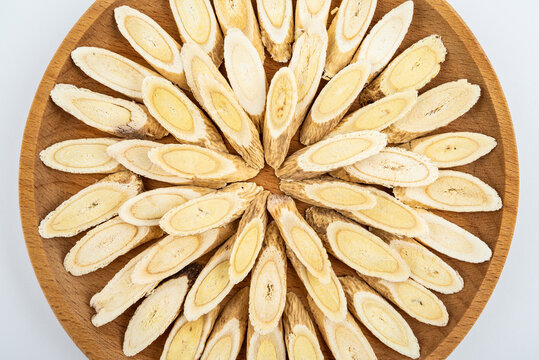 Astragalus membranaceus tablets on a plate on white background