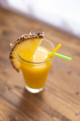 pineapple juice in a glass with a slice of pineapple