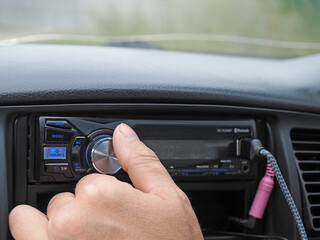  Man using car audio stereo magnet. adjusting the volume of the car magnet. selective focus