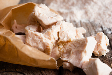broken yeast cake on wax paper, weathered wood table background
