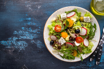 Fresh salad with vegetables,  cheese and olives. Diet and healthy food concept. Top view, text space