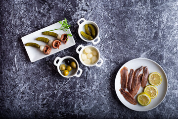 Obraz na płótnie Canvas anchovy onion and gherkin skewers on a plate surrounded by ingredients