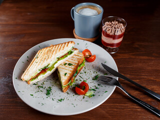 Toasted shredded chicken breast and salad sandwich served on a rustic wooden table wrapped in a brown paper wrapper tied with string with vignetting and copyspace