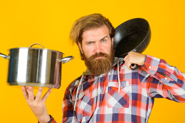 Kitchenware. Cooking vessels. Kitchen advertising. Bearded man with saucepan and frypan. Man chef with pot. Saucepan. Cooking. Cooking utensils.