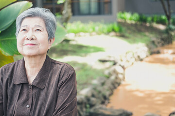 Naklejka na ściany i meble elder woman resting in garden. elderly female relaxing outdoors. senior leisure lifestyle
