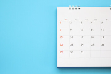 calendar page close up on blue background business planning appointment meeting concept