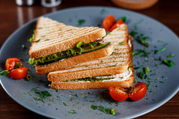 Toasted shredded chicken breast and salad sandwich served on a rustic wooden table wrapped in a brown paper wrapper tied with string with vignetting and copyspace