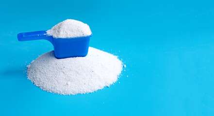 Detergent powder with measuring spoon for clothes washing. Laundry concept.